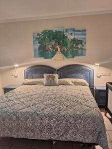 una camera con un grande letto e un dipinto sul muro di Rocas del Mar Apartment a Costa Del Silencio