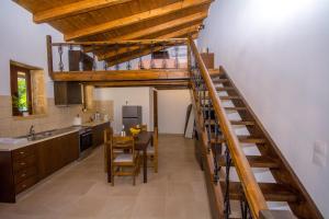 una cocina con una escalera que conduce a una cocina con mesa en Christina Apartments 2 en Dhrapaniás