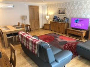 a living room with a couch and a tv at Roslin Self Catering in Roslin