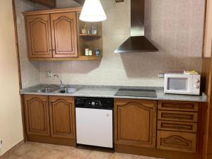 a kitchen with a white microwave and a sink at Casa Valentí in Taüll