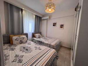 two twin beds in a room with a chandelier at فيلا مميزه جدا في الساحل الشمالي ستيلا هايتس Stella Heights - Sidi Abd El-Rahman villa type M in El Alamein +36 photos