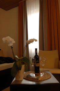 a table with a bottle of wine and two glasses at Adler Hotel Garni in Ostfildern
