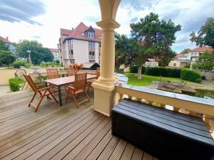 una terraza de madera con mesa y sillas. en Villa Le Palais Quedlinburg, en Quedlinburg