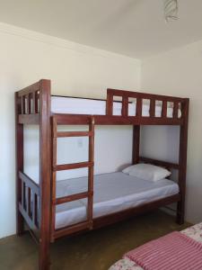 two bunk beds in a room with a ladder at Chalés Rosados in Serra de São Bento
