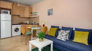 Il comprend un salon avec un canapé bleu et une cuisine. dans l'établissement Sunlit Retreat with Garden Haven, à Fuengirola