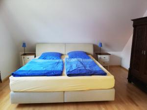Una cama en una habitación con almohadas azules. en Ferienwohnung an der Windmühle, en Weimar