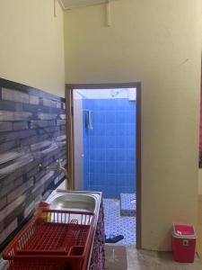 a bathroom with a tub and a blue shower at Tina Homestay Budget in Ketereh