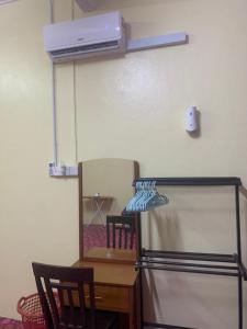 a room with a refrigerator and a table with two chairs at Tina Homestay Budget in Ketereh