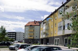 eine Gruppe von Gebäuden mit Autos auf einem Parkplatz in der Unterkunft Apartman Dada in Krapinske Toplice