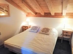 een slaapkamer met een groot bed in een kamer met houten plafonds bij Appartement Morillon 1100, 4 pièces, 6 personnes - FR-1-412-13 in Morillon