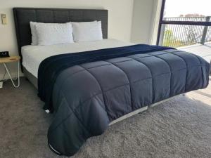 um quarto com uma cama grande e um cobertor azul em Arthurs Holiday Villa em Arthurs Seat