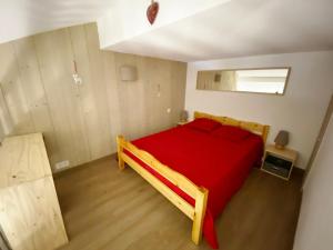 sypialnia z drewnianym łóżkiem z czerwoną pościelą w obiekcie Charmant 2 Pièces Rénové 6 Pers, Balcon, Proche Pistes et Commerces - Morillon 1100 - FR-1-412-82 w mieście Morillon