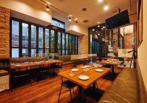 a restaurant with wooden tables and chairs and windows at APA Hotel Hatchobori-eki Minami in Tokyo