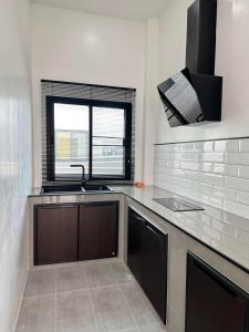 a kitchen with a sink and a window at AKIRA Villa in Buriram