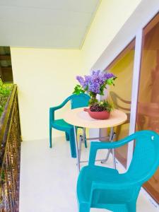 einen Tisch mit zwei Stühlen und eine Vase mit Blumen darauf in der Unterkunft cottage in tsemi (Borjomi) in Bordschomi
