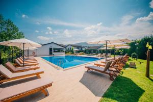 a swimming pool with lounge chairs and umbrellas at Sapanca Cayir Cimen Otel in Sapanca