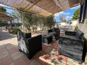 a group of chairs sitting on a patio at Holiday Home Eurovillage in Torre Lapillo