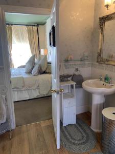 a bathroom with a sink and a bed with a window at The Suites At Ty Anne in Beaumaris