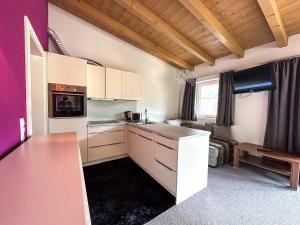 a kitchen with white cabinets and a purple wall at Harakiri lodgings und ApresSki in Mayrhofen