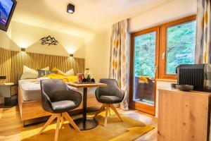 a bedroom with a bed and a table and two chairs at Gästehaus Julia in Ischgl