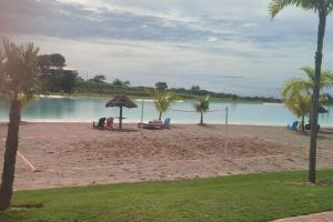 a beach with a net and palm trees and water at Mar Adentro Lujoso Departamento con Playa in Santa Cruz de la Sierra