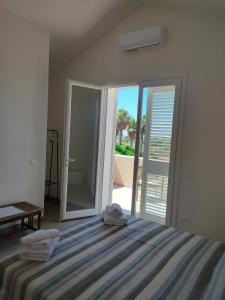 a bedroom with a bed and a sliding glass door at La casetta della Pigna Verde in Marsala