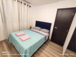 ein Schlafzimmer mit einem Bett mit zwei rosa Handtüchern darauf in der Unterkunft Mar Adentro Lujoso Departamento con Playa in Santa Cruz de la Sierra