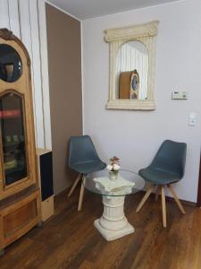 ラーンシュタインにあるFerienwohnung Claudia & Dinoの椅子2脚、テーブル1台、鏡1台が備わる客室です。