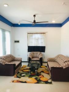 a living room with two chairs and a rug at Villa Moon breeze Nilaveli in Trincomalee