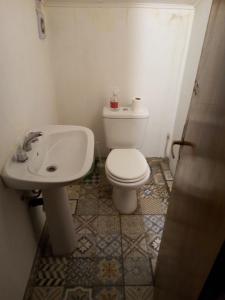 a bathroom with a white toilet and a sink at Hostel Piltri in El Bolsón