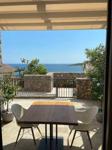 - une table et des chaises sur une terrasse avec vue sur l'océan dans l'établissement Lustica Bay Marina Studio****, à Radovići
