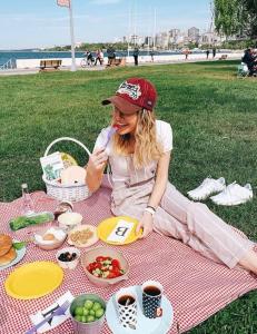 a woman sitting on a picnic blanket with food at Yıldız in Istanbul