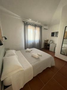 a bedroom with a white bed with towels on it at Bent’E Mari in Girasole