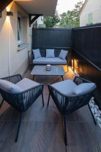 a patio with two chairs and a table and a couch at Le splend'id à 10min de Disneyland in Chessy