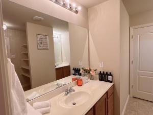 a bathroom with a sink and a large mirror at The Queens luxury palace in Grand Prairie