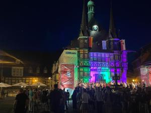 una folla di persone che di notte si trovano davanti a un castello. di Altstadtapartments a Wernigerode