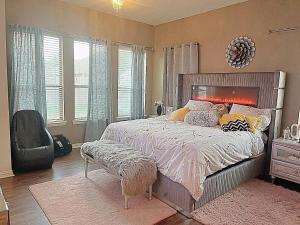 a bedroom with a large bed in a room with windows at The Queens luxury palace in Grand Prairie