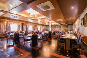 Heritage Khirasara Palace في راجكوت: مطعم به طاولات وكراسي في غرفة