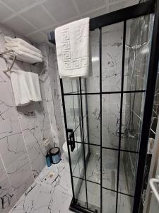 La salle de bains est pourvue d'une douche et de murs en marbre blanc. dans l'établissement Lords Mansion, à Istanbul