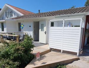 una pequeña casa blanca con garaje blanco en Humlebo en Åsa