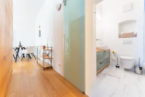 a white bathroom with a toilet and a table at Cozy-City Appartement in Krems an der Donau