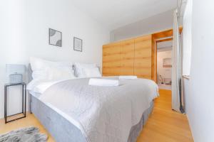 een slaapkamer met een groot wit bed met een houten hoofdeinde bij Cozy-City Appartement in Krems an der Donau