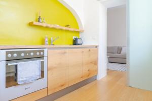 a kitchen with a stove and a yellow wall at Cozy-City Appartement in Krems an der Donau