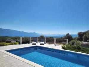 una piscina con 2 sillas de jardín junto a ella en Villa Ancora en Selca