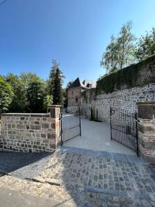 una entrada a una pared de piedra con una puerta en Holiday house for design lovers! en Chimay