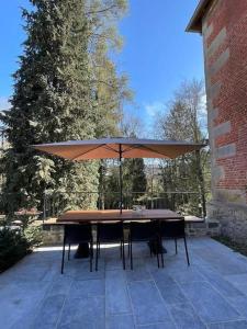 una mesa con sombrilla en el patio en Holiday house for design lovers!, en Chimay