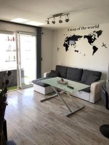 a living room with a couch and a map of the world at Bord canal tranquillité demain nous appartient in Sète