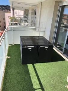 a balcony with a black cabinet on the floor at Bord canal tranquillité demain nous appartient in Sète