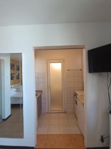 un bagno con una porta e una televisione in una stanza di Old Town View Studio a Bucarest