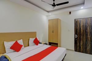 - une chambre avec un grand lit et des oreillers rouges dans l'établissement Hotel Dafodil, à Allahābād